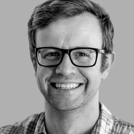Smiling man with glasses and plaid shirt in black and white portrait photo
