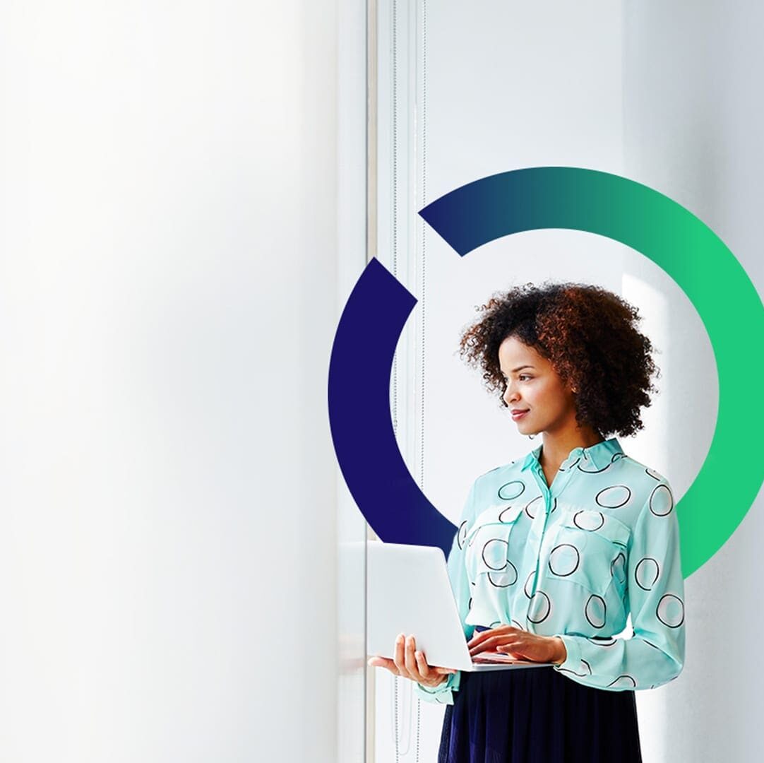 A woman in a patterned shirt stands by a window, holding a laptop. Circular graphic in background.