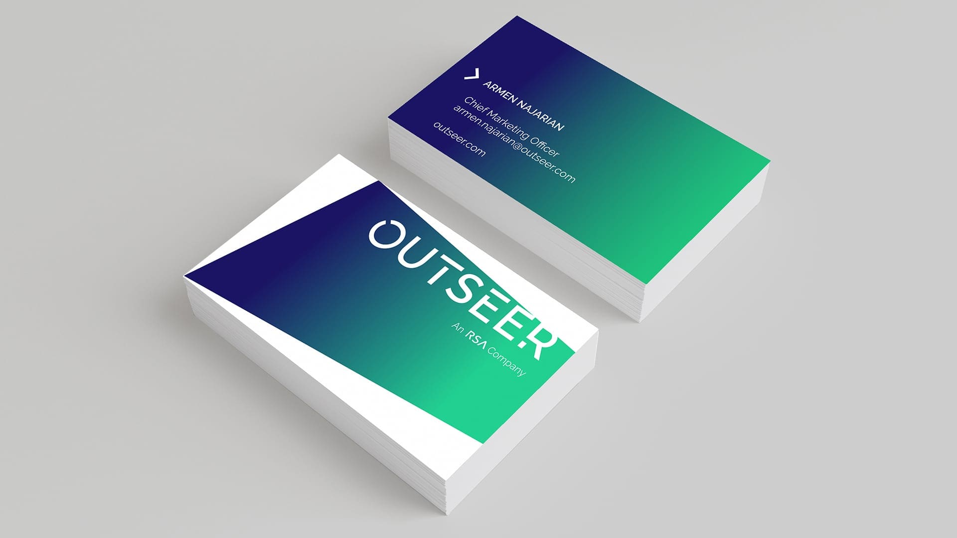 A stack of business cards featuring a gradient design in shades of blue and green. The front displays the name "ARMEN NAJARIAN," title "Chief Marketing Officer," and email "armen.najarian@outseer.com." The back prominently